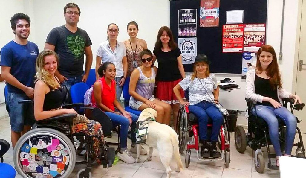 Grupo de estudantes se reúne desde o segundo semestre do ano passado para discutir questões de acessibilidade e visibilidade das pessoas com deficiência na UFSC. Foto: Divulgação Por Uma UFSC Inclusiva. #ParaCegoVer Um grupo de dez pessoas e um cão guia posam para a foto. Cinco deles estão em pé, atrás dos que estão sentados. Três mulheres estão com cadeira de rodas e outras duas estão sentadas em cadeira comum. O cão guia de pelos brancos está de costas para a foto.