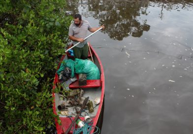 Pescador retira lixo das margens do rio. No meio do material recolhido havia uma bateria de carro